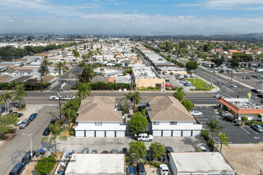 A bird's eye view of a parking lot with a building in the center.